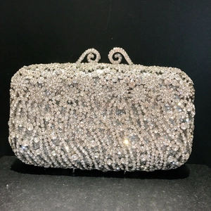 Elegant silver clutch bag featuring full rhinestone embellishment and crystal metallic clasp