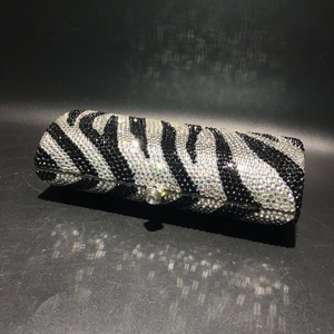 Detailed view of the zebra pattern crystal clutch with a luxury rhinestone snap closure