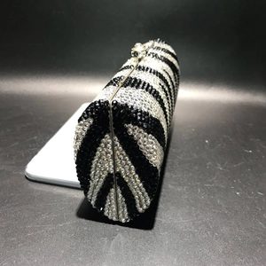 Detailed side view of luxury evening clutch with sparkling zebra pattern crystal rhinestones