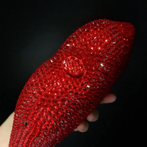 Close-up of red rhinestone encrusted lip clutch bag with sparkling diamond ball clasp