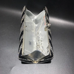 Detail view of the zebra pattern rhinestone clutch bag interior with a detachable chain