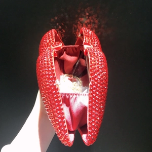 Close-up of red lip-shaped clutch bag interior with satin lining and gold chain