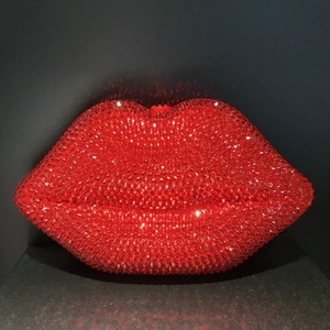 Macro shot of sparkling red crystals on a lip-shaped clutch evening bag for women