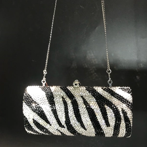 Macro shot of zebra pattern rhinestones and sphere clasp on a rectangle evening clutch