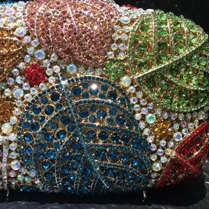 Detailansicht bunter Kristalle und Blattmuster auf der eleganten Metall-Abendtasche
