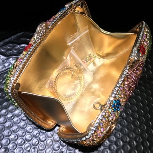 Details der Abendtasche mit goldenem Innenfutter, Kette und bunten Strasssteinen