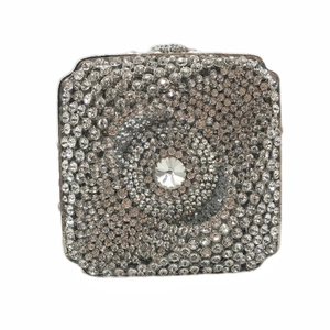Détail macro d'une pochette carrée argentée avec strass et cristal central scintillant