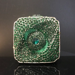 Détail d'une pochette de soirée carrée avec strass vert émeraude et pierre centrale de luxe