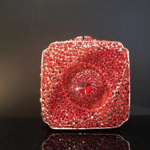 Vue détaillée de la pochette rouge en strass avec un grand cristal central serti