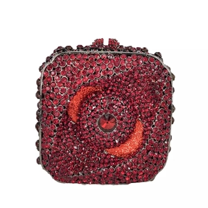 Détail macro d'une pochette de soirée rouge sertie de strass avec motif œil central