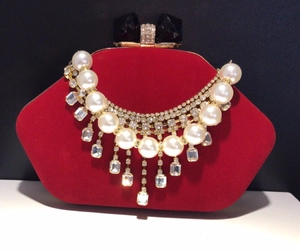 Luxurious bridal pearl necklace with multi-layer rhinestones on red velvet background