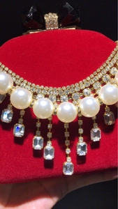 Elegant multi-layer bridal necklace with pearls and rhinestone tassels on red velvet