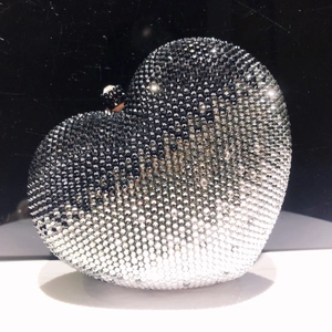 Dettaglio pochette da sera a cuore con strass sfumati e chiusura a sfera in metallo