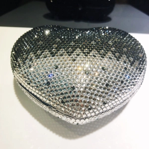 Dettaglio macro della borsa clutch a cuore con strass sfumati dal nero all'argento