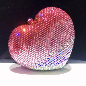 Dettaglio della borsa da sera a cuore con strass sfumati rosa e chiusura in metallo di lusso