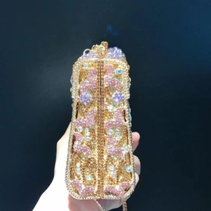 Detail of luxury trapezoid clutch with pink floral rhinestones and gold chain strap