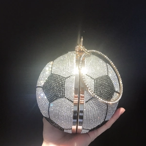 Detail of crystal-encrusted football-shaped evening bag with metal ring handle and clasp