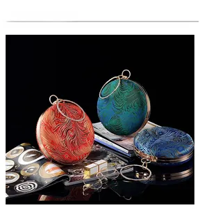 Detailed peacock feather embroidery on luxury round evening bags in red, green and blue