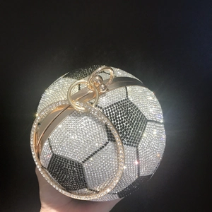 Detailed close-up of spherical soccer clutch bag with black and white rhinestones