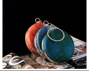 Close-up of circular satin clutch bags featuring elegant peacock feather embroidery