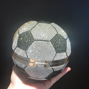 Detail of hand holding a soccer ball evening clutch bag with black and silver rhinestones