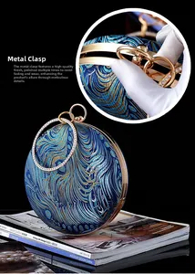 Detail of durable gold-plated buckle and peacock embroidery on round luxury evening bag