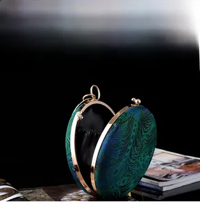 Detailed interior of circular peacock embroidery clutch showing black lining and gold frame