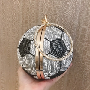 Close-up of black and white crystal soccer evening bag with gold ring handle