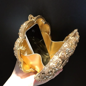 Detail view of the interior space of this gold crystal clutch bag with a smartphone inside