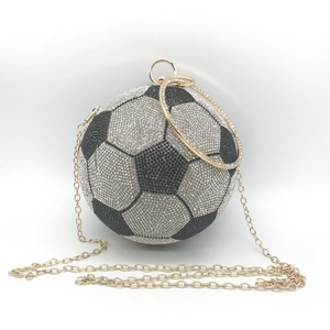 Detail of football shaped clutch bag with sparkling black and white rhinestones and gold chain