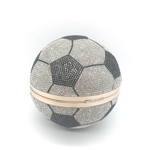 Close-up of black and white rhinestones and gold metal frame on soccer ball evening bag