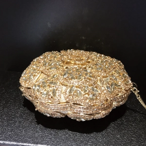 Macro view of crystal flower patterns and gold rhinestones on luxury clutch bag
