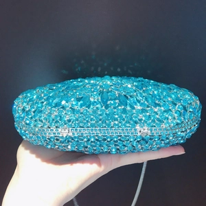 Close-up of blue rhinestone evening clutch with crystal inlay and metal chain strap