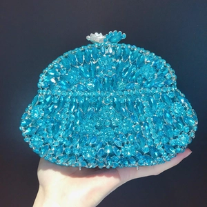 Close-up of luxury blue rhinestone evening clutch bag with ornate silver floral clasp