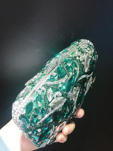 Detail view of emerald and white rhinestones on a luxury evening clutch purse