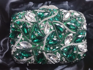 Detail of luxury emerald and white crystal evening clutch with sparkling metal clasp