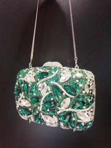 Close-up of emerald green and white crystal rhinestones on an evening clutch bag