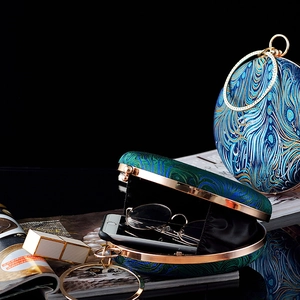 Elegant peacock feather embroidery evening bag with golden circular handle and metal frame