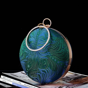 Peacock embroidery round evening bag with gold rhinestone handle on black background
