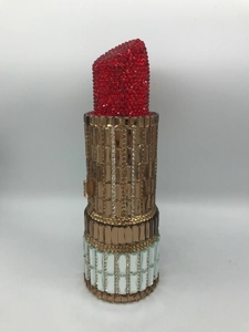 Détail de pochette rouge en forme de rouge à lèvres avec strass et cristaux dorés