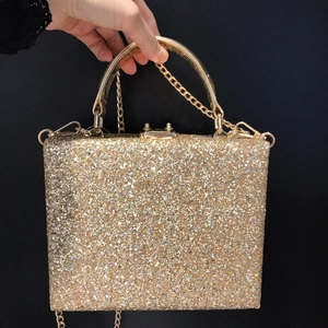 Sparkling gold sequin evening clutch bag with round metal handle and chain strap