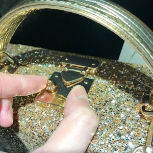 Chic gold sequin evening clutch bag with metallic handle and secure snap closure