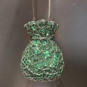 Détails de la pochette de soirée verte avec strass brillants et fine chaîne argentée
