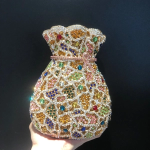 Détail de la pochette dorée sertie de cristaux colorés et d'un nœud en strass