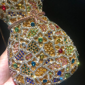Détail macro de la pochette de soirée en forme de vase avec strass colorés et chaîne