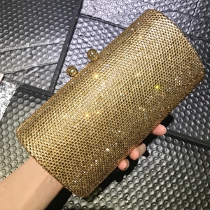 Elegant champagne gold rhinestone clutch bag with sparkling finish and twin sphere clasps