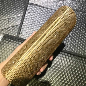 Elegant gold cylindrical evening clutch bag fully encrusted with sparkling rhinestones