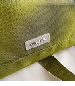 Gros plan d'un sac cabas en nylon ripstop vert herbe avec patch logo de marque gris
