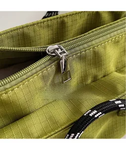 Vue macro de la fermeture éclair en métal poli et du tissu en nylon ripstop vert