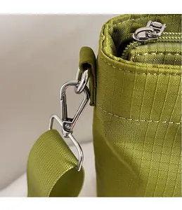 Détail du crochet en métal argenté et du tissu oxford sur un sac cabas vert